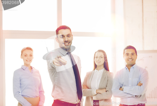 Image of businessman in office pointing finger at you