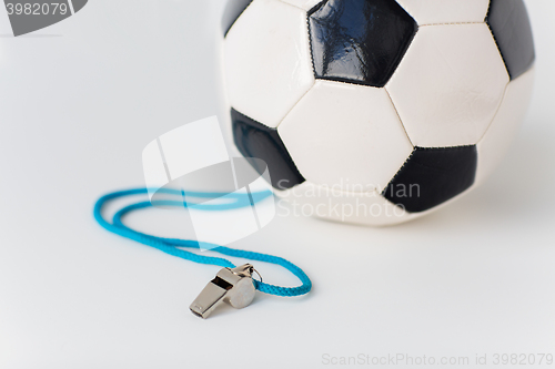 Image of close up of football or soccer ball and whistle