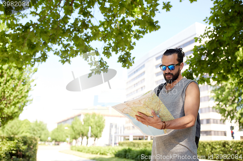 Image of man traveling with backpack and map in city