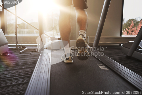 Image of close up of man legs walking on treadmill in gym