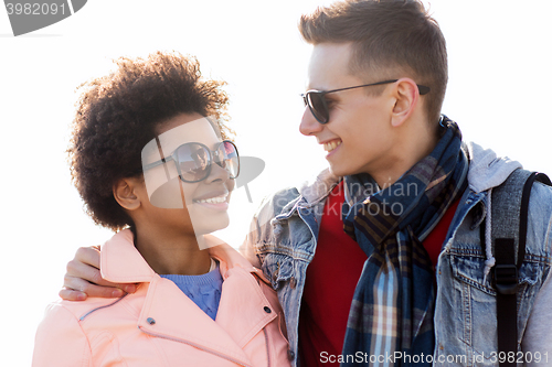 Image of happy teenage friends in shades talking outdoors