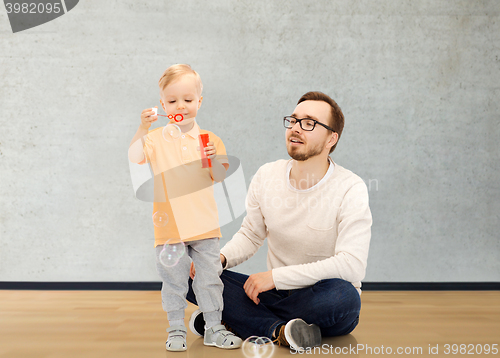 Image of father with son blowing bubbles and having fun