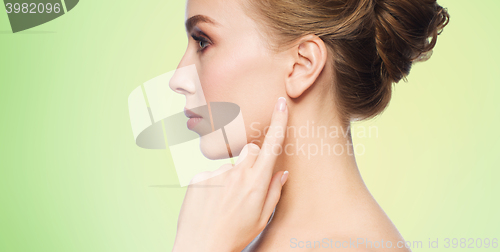 Image of beautiful woman pointing finger to her ear