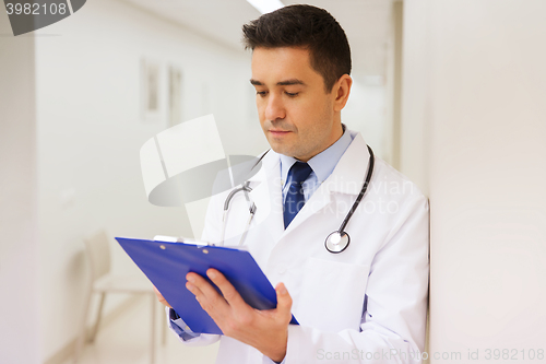 Image of doctor writing to clipboard at hospital