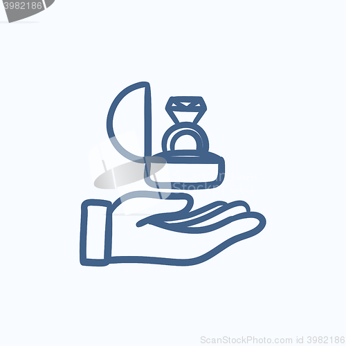 Image of Hand holding gift box with ring sketch icon.