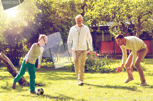 Image of happy family playing football outdoors