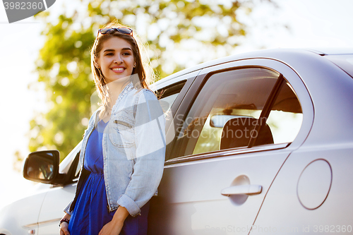 Image of happy teenage girl or young woman in car