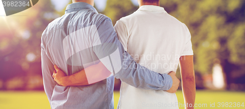 Image of close up of happy male gay couple hugging