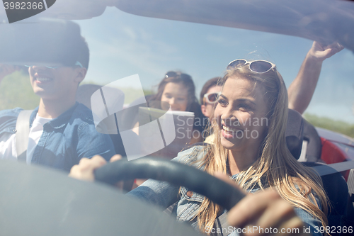 Image of happy friends driving in cabriolet car