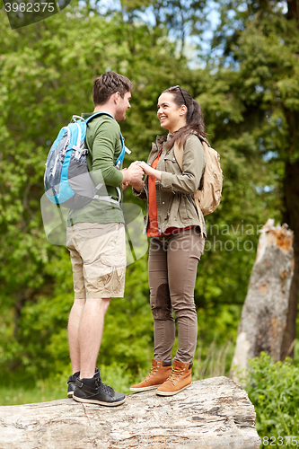 Image of happy couple with backpacks hiking outdoors
