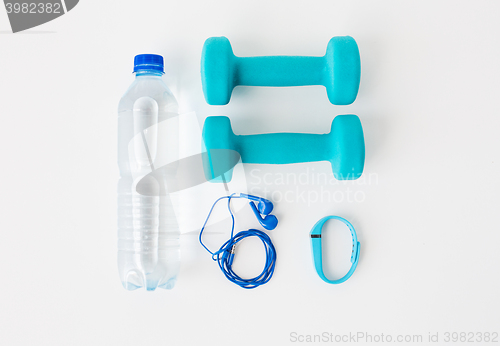 Image of dumbbells, fitness tracker, earphones and bottle