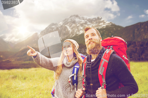 Image of smiling couple with backpacks hiking