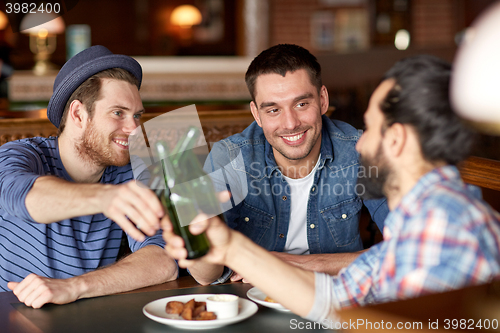 Image of happy male friends drinking beer at bar or pub