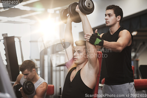 Image of group of men with dumbbells in gym