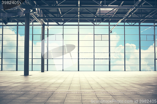 Image of airport terminal room over blue sky and clouds