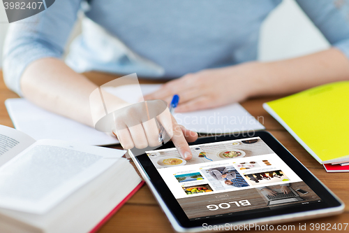 Image of close up of student with tablet pc and notebook