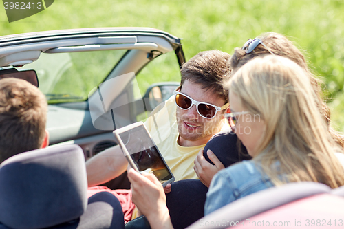 Image of friends with tablet pc driving in cabriolet car