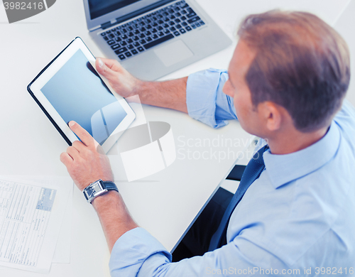 Image of businessman with tablet pc and papers in office