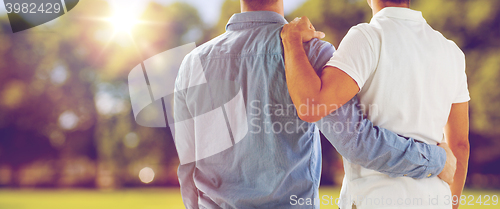 Image of close up of happy male gay couple hugging