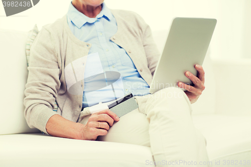 Image of senior woman with tablet pc and credit card