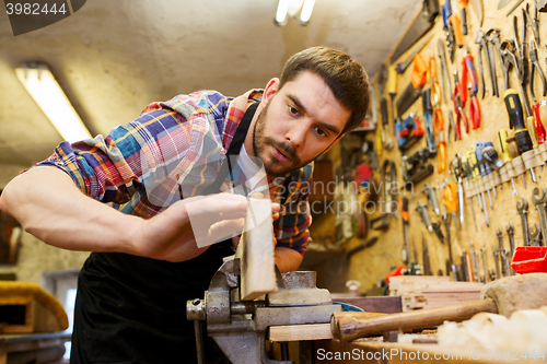 Image of carpenter working with plane and wood at workshop