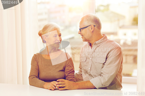 Image of happy senior couple sitting on sofa at home