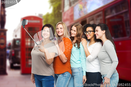 Image of happy women taking selfie by smartphone in london