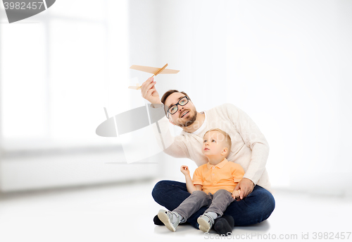 Image of father and little son playing with toy airplane