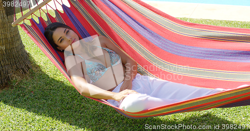 Image of Calm young woman in hammock