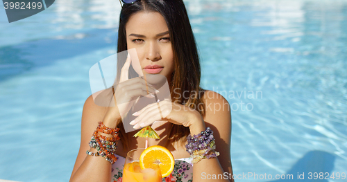 Image of Sexy young woman drinking a tropical cocktail