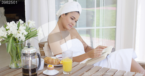 Image of Gorgeous young woman relaxing with a book