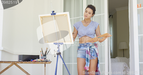 Image of Attractive woman artist painting on her patio