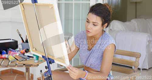 Image of Attractive female artist working on a canvas