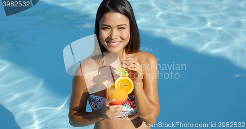 Image of Happy vivacious woman with a tropical cocktail