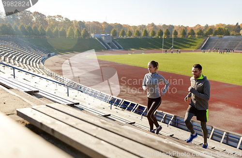 Image of happy couple running upstairs on stadium