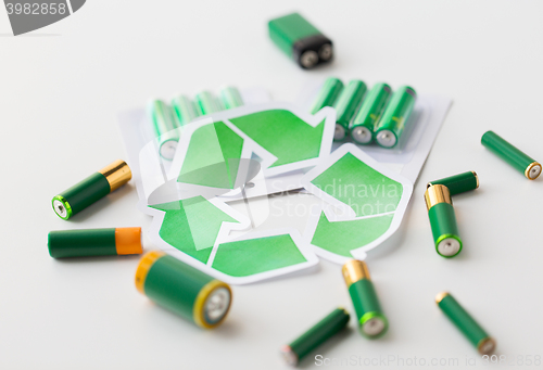 Image of close up of batteries and green recycling symbol