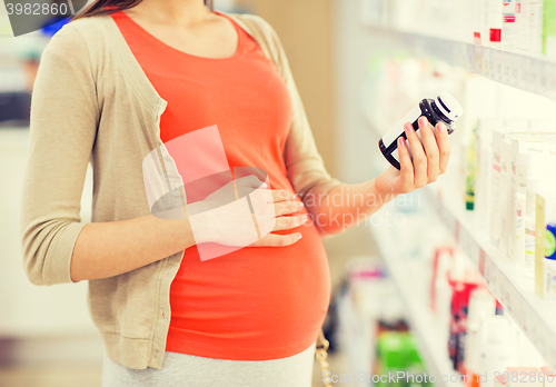 Image of pregnant woman with medication at pharmacy