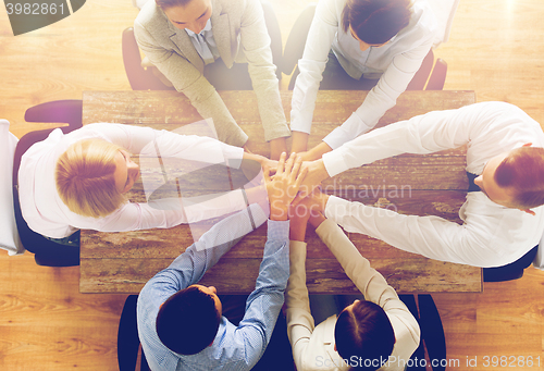 Image of close up of business team with hands on top