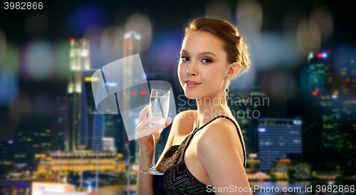 Image of young asian woman drinking champagne at party