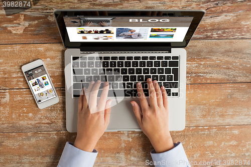Image of close up of hands with laptop and smartphone