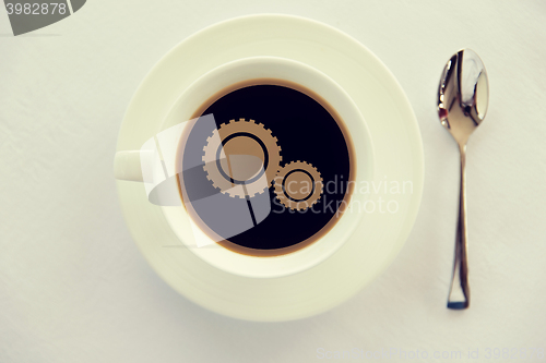 Image of cup of coffee with cogwheel symbol and spoon