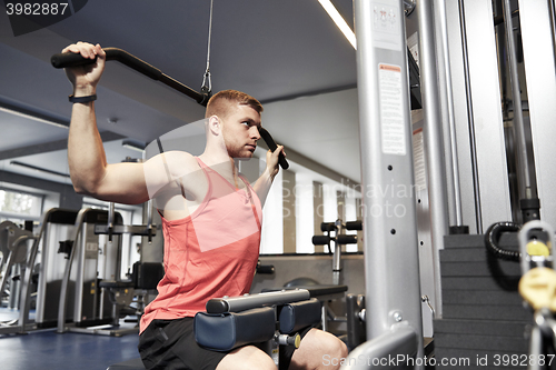 Image of man flexing muscles on cable machine gym