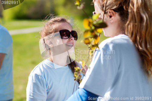 Image of volunteers family with tree seedling in park