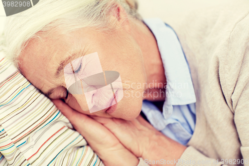 Image of happy senior woman sleeping on pillow at home