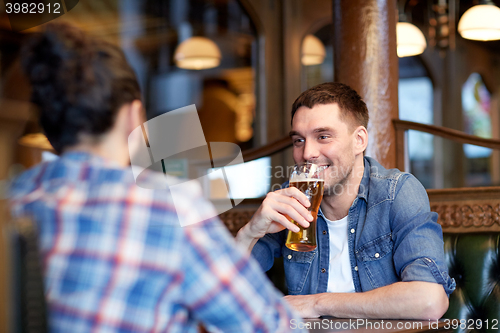 Image of happy male friends drinking beer at bar or pub