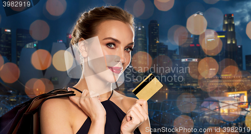 Image of woman with credit card and shopping bags in city