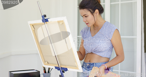 Image of Artistic young woman working on a painting