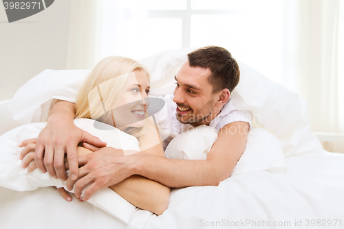Image of happy couple in bed at home