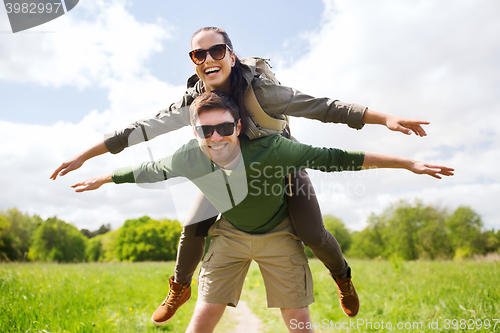 Image of happy couple with backpacks having fun outdoors