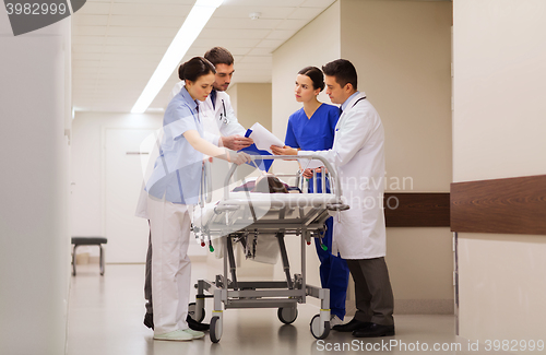 Image of medics with woman on hospital gurney at emergency